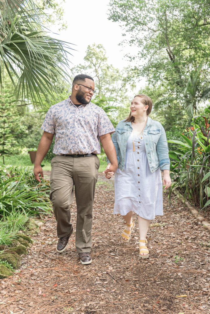 proposal photography in Orlando, engaged couple walking on a path